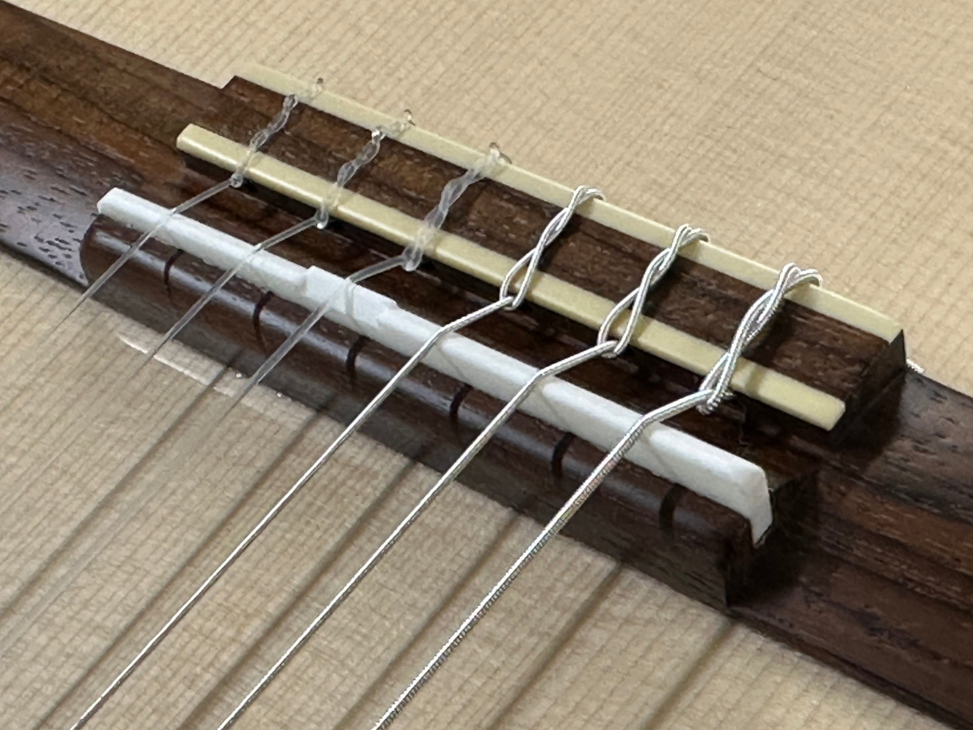 Close-up of the compensated bone saddle of a Kantare classical guitar